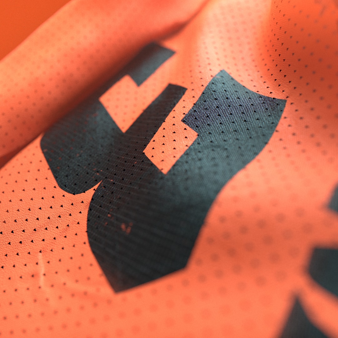 Orange jersey fabric with a dark graphic.
