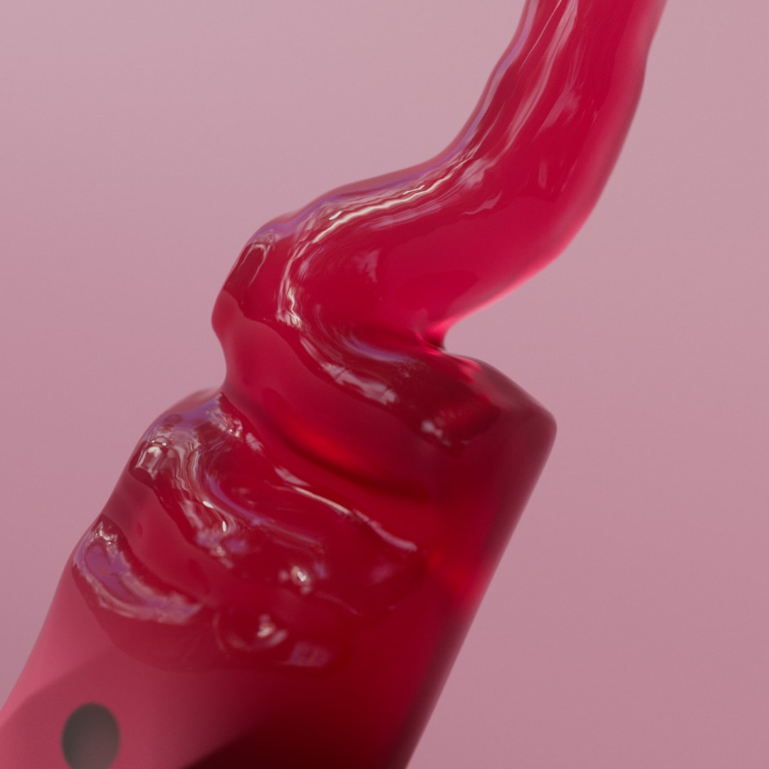 A glossy berry-colored ribbon curls over a pink toothbrush.
