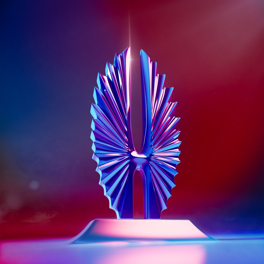 A chrome GLAAD statuette reflecting pink and blue against a red background.