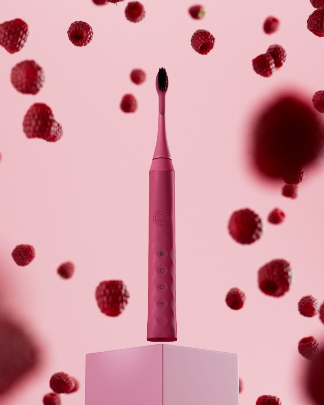 A pink Burst Berry toothbrush stands among floating raspberries.