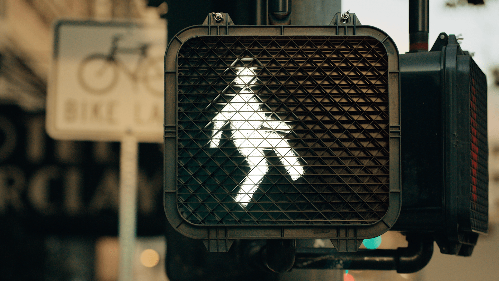 An illuminated pedestrian crossing sign.