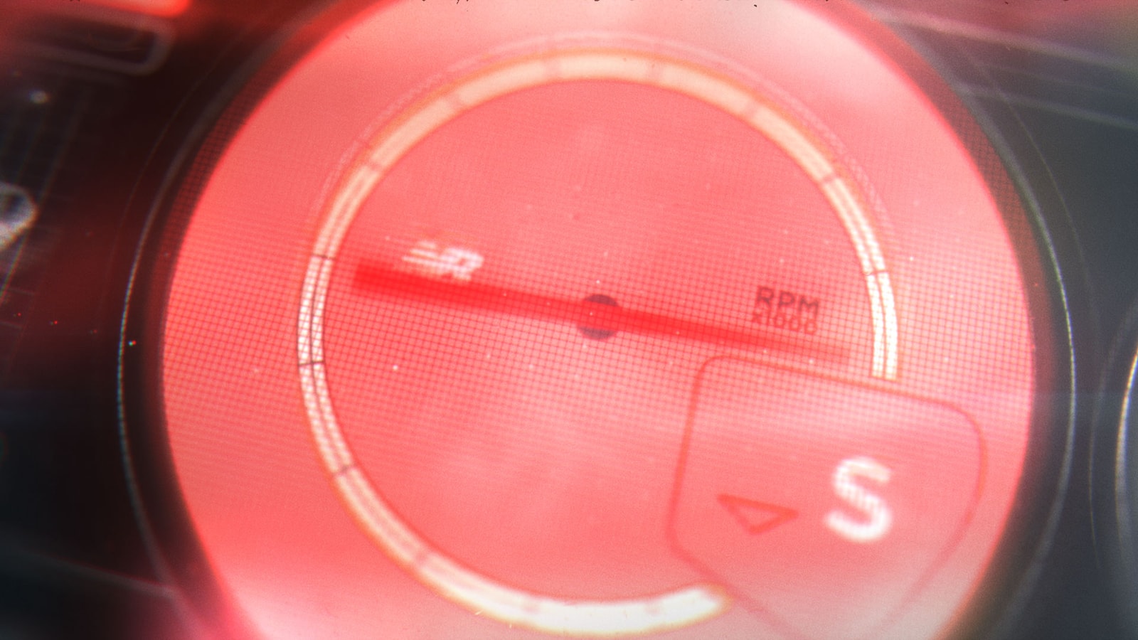 Close-up of an illuminated red speed gauge.