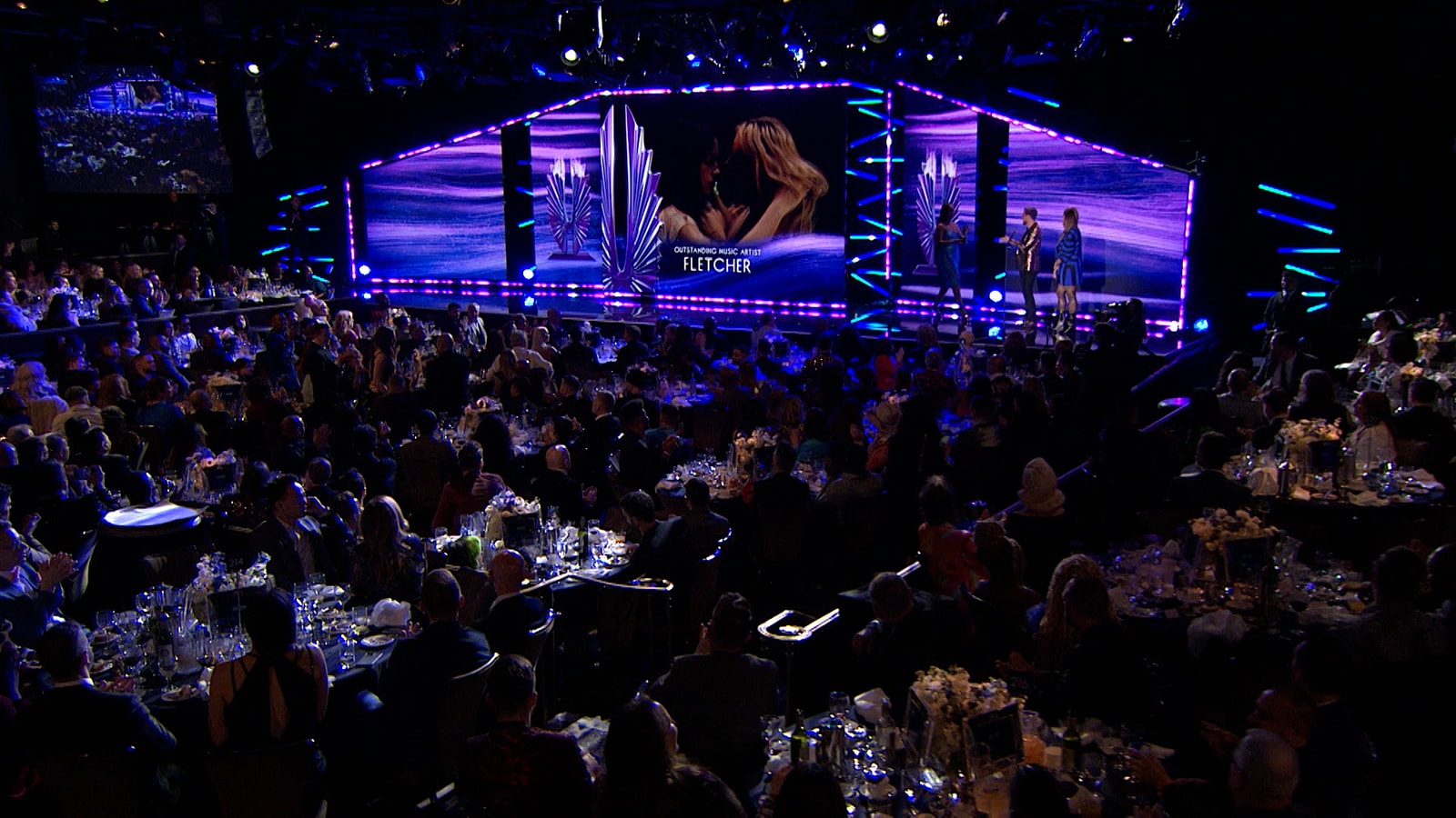 A wide view of the audience and purple-lit stage at the 2023 GLAAD Media Awards.