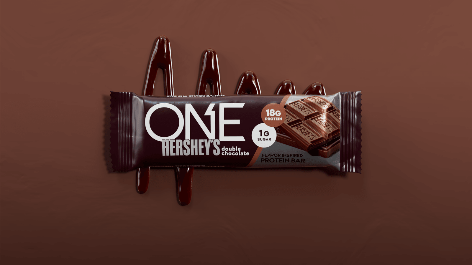 ONE Hershey’s protein bar and chocolate on a brown background.
