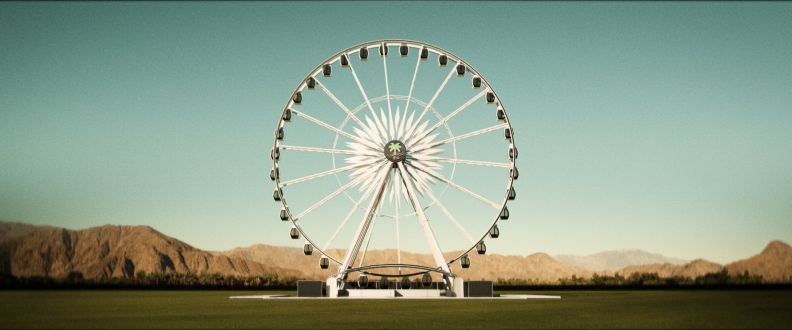 A Ferris wheel stands against the mountains in the Coachella desert.