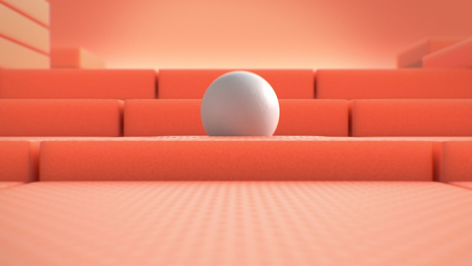 A white sphere rests on coral foam steps.